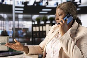 Businesswoman in telephone call with shareholders developing sales strategies to increase market share and profitability. Manager talking on phone with partners to analyze sales performance metrics photo