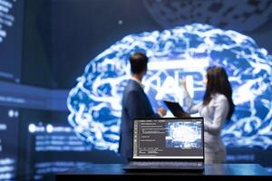 Focus on laptop in workplace used by AI researchers working with artificial intelligence in blurry background. Close up of notebook used by workers developing AI systems in tech startup photo