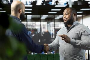 Friendly business managers attending briefing meeting with CEO to share new ideas for profit growth, shaking hands. Man talking to director to explain startup evolution vision, doing handshake photo