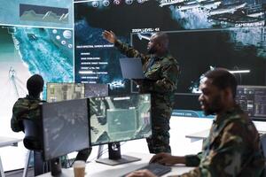 Group of soldiers in a secure office environment collaborates on intelligence analysis, data processing and strategic planning. Crucial for maintaining national security and operational efficiency. photo