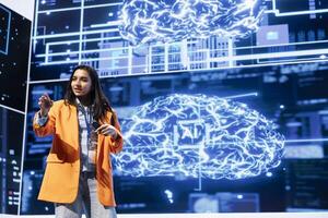 Cheerful engineer talking at AI tech summit event gathering professionals seeking to discover latest AI solutions. Upbeat speaker presents how can AI be leveraged to accelerate innovation photo