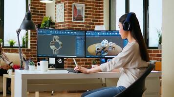 Asian professional engineer works on coding industrial designs using advanced software tools. Living room office includes dual monitors and technical equipment for high productivity. Camera A. photo