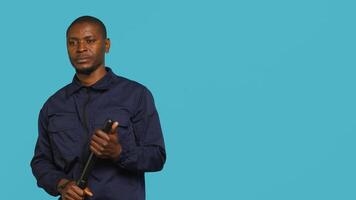 Portrait of security staff member tasked with evicting trespassers, intimidating them with baton. Patrolling agent maintains secure environment using truncheon weapon, studio background, camera A photo