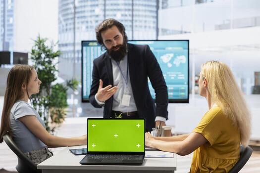 Financial advisor doing presentation with mockup laptop in front of clients, using chroma key notebook to present economic services such as stock exchange analysis and portfolio monitoring photo