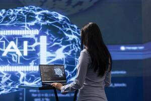 Admin using laptop to maintenance artificial intelligence neural networks made up of interconnected nodes layers. Woman using AI system aiding in processing and transmitting information photo