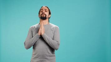 Pious man praying to his god, asking for forgiveness. Spiritual person doing worship hand gesturing, confessing, begging for pardon, isolated over studio background, camera B photo