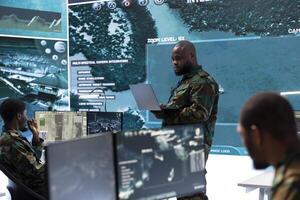 Military team in a command post base uses advanced technology, including satellite imagery and surveillance cctv systems. Support strategic planning and monitor potential threats, army operations. photo