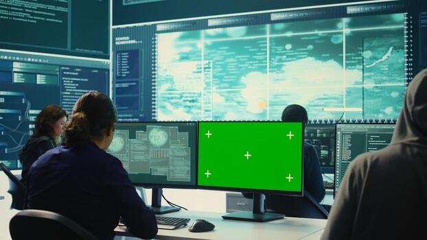 Hacking specialist works with an isolated chroma key display in high tech agency office, securing national servers with state secrets. Governmental hacker examines threat detection measures. Camera B. photo