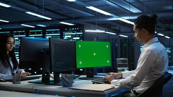 System administrator overseeing data center using green screen computer, ensuring system can handle networking tasks. IT expert in server room tracking network traffic with mockup PC, camera B photo