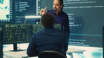 Cyber defense team working in a governmental security operations center. Experts ensuring cybercrime prevention and data breach protection, examining information on a big screen. Camera A. photo