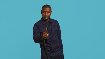 Portrait of security guard doing no gesturing with finger, prohibiting access while overseeing premises. Private law enforcement worker barring people from entering place, studio backdrop, camera B photo