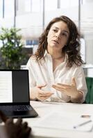 HR specialist using laptop to reviewing candidate CV, asking questions about qualifications. Person getting hired by recruiter using notebook after proving necessary skills for job photo