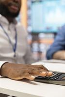 Financial adviser using a calculator to make a projection for old people pension and future income, assisting them in choosing a suitable retirement plan for stability in the future. Close up. photo