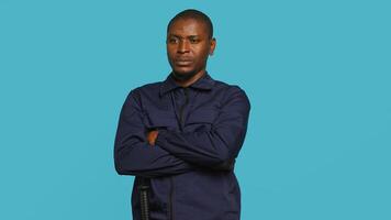 Portrait of smiling security agent securing assigned post, isolated against studio background. African american guardian prepared to handle security breaches and diffuse tense situations, camera A photo