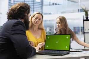 Financial advisor making investment performance analytic report on green screen laptop for clients. Agent preparing portfolio economic evolution summary for family on chroma key notebook photo