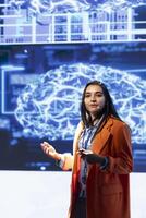 Presenter talking in front of world leading technology experts and researchers meeting at artificial intelligence conference. Data scientist showcasing latest developments in AI industry photo