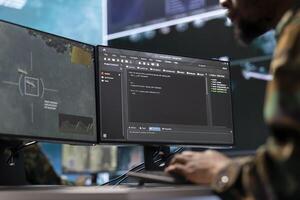 IT analyst in a high tech base of operations handling surveillance activity and ensuring security protocols. Military command post crew collecting real time data to achieve mission objectives. photo