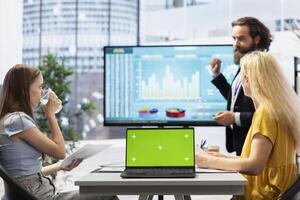 Financial advisor provides economic services to family, showing data on isolated screen laptop. Agent chatting with clients about their banking accounts, doing presentation on chroma key notebook photo