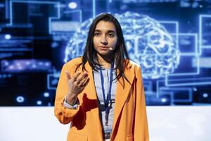 Speaker talking with viewers on stage at AI conference bringing together leading experts and researchers to explore latest developments in artificial intelligence and machine learning photo