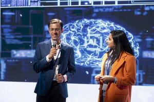 Presenter and specialist guest talking at AI summit bringing together tech startups professionals, exploring latest developments in artificial intelligence and deep learning technology photo