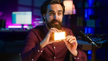 Reviewer discussing with viewers about mini led lights during live broadcast on internet, close up. Influencer chatting with fans during stream, filming RGB lighting device in studio, camera A photo