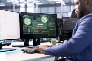 Software developer in data center getting access denied notification on PC screen, trying to access server files after they were locked by hacker using ransomware, receiving error photo