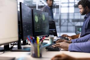 Programmers in server hub getting access granted notification on PC screen, managing to access server files after they were locked by hacker using ransomware, receiving aid from team members, close up photo