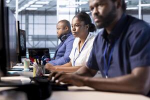 Team of data center engineers creating technical documentation for software applications. African american computer scientists working in server hub, maintaining databases photo