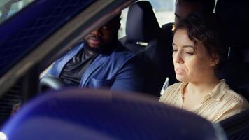 Woman buying car, doing test drive, evaluating if steering wheel feels comfortable, looking out for potential lag. Customers in vehicle with salesman driving to see how automobile reacts, camera B photo