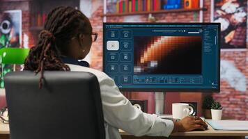 Person at home getting tasks done with AI program turning text prompt into videos. Woman using computer to make use of text to artificial intelligence generative models, camera B photo