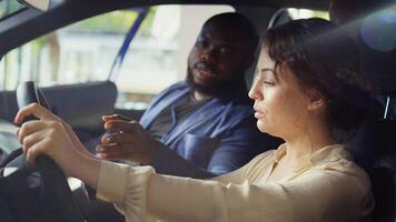 Customers doing pre purchase inspection of car in showroom parking lot, looking for possible faults. Clients experiencing driving conditions in new vehicle before making investment, camera B photo