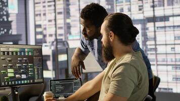 Manager correcting programmer mistakes while conducting code review to fix errors, identifying technical issues with company software. Team leader supervising IT staff member optimizing code, camera A photo
