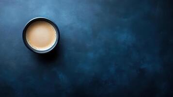 Aerial view of coffee cup on dark blue background for minimalistic coffee concept photo
