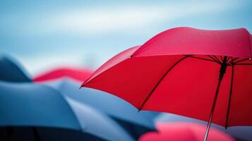 Close-up of a red umbrella among blue ones depicting concept of individuality photo