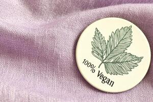 Vegan Badge on Purple Fabric EcoFriendly Symbol of PlantBased Lifestyle photo