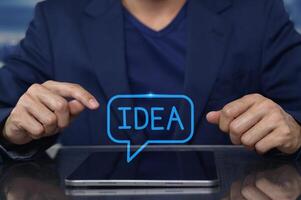 Man in Suit Gestures at Tablet with Idea Concept Bubble Above photo
