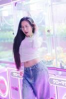 Young Woman Posing in Arcade with Neon Lights and Plush Toys photo