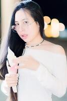 Young Woman Enjoying Ice Cream at Night with Blurred Background photo