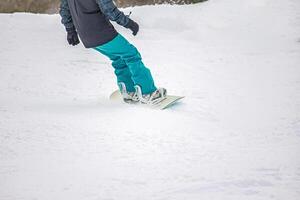 Close-Up of snowboarder in action on the white snow photo