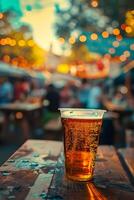 refreshing craft beer in clear cup, set against vibrant outdoor scene with twinkling lights and lively atmosphere photo