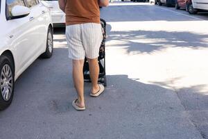 Father taking a stroll with a child in a stroller on a sunny day in a busy residential area photo