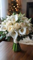Elegant bridal bouquet with white calla lilies and roses in front of christmas tree photo