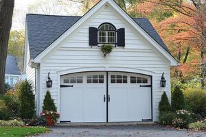 White garage door with black trim and window box displaying fall colors photo