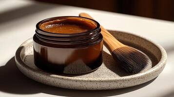 A rich brown cream nestled in an elegant jar with a brush ready for application photo