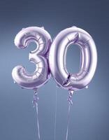 Celebrating a milestone birthday with shiny silver balloons displaying the number thirty against a blue background photo