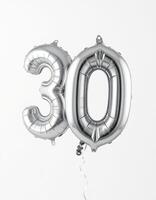Celebrating a milestone with shiny silver balloons marking 30 years at a birthday party photo