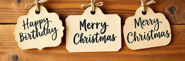 Colorful and festive greeting tags hang on wooden background celebrating happy birthday and merry Christmas photo