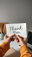 Expressing gratitude with a handwritten thank you note in a cozy workspace setting photo