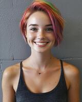 Portrait of a young woman with rainbow colored hair and freckles smiling at the camera photo