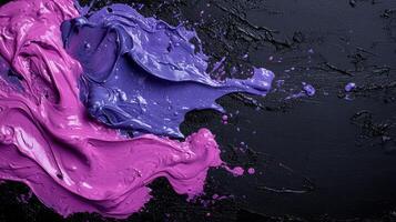 Abstract purple and violet paint swirls on black background photo